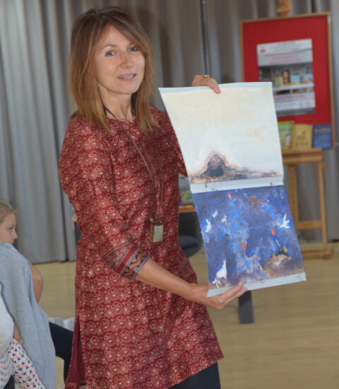 kobieta pokazuje planszę przedstawiającą ilustrację