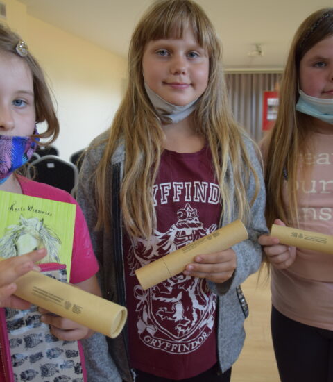 trzy dziewczynki w rękach trzymają kartonowe tuby