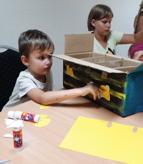 dzieci malują farbami kartonowe pudełka