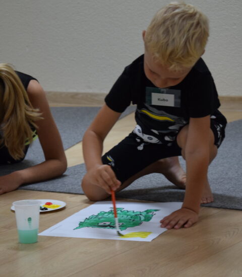 chłopiec i dziewczynka malują farbami na podłodze