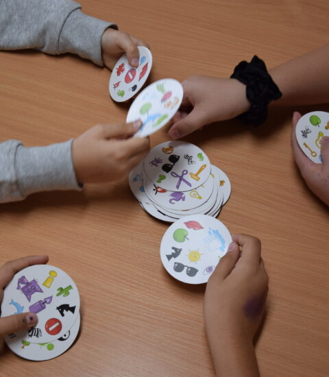 dziecięce ręce trzymające okrągłe karty do gry
