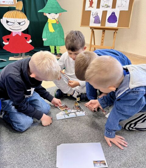 dzieci układają papierowe puzzle