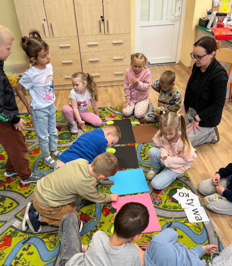 dzieci układają kolorowe kartki papieru