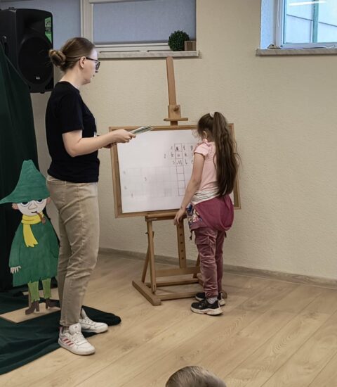 dziewczynka pisze na tablicy, obok stoi kobieta