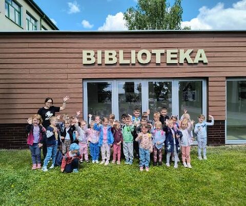 grupowe zdjęcie przed siedzibą biblioteki