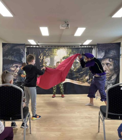 aktor z trojgiem dzieci bawią się chustą