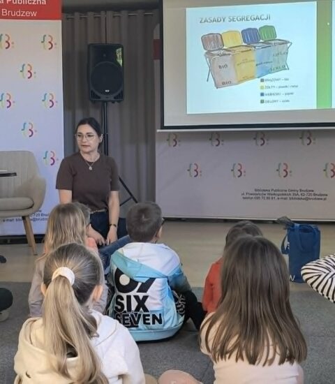 kobieta kuca, przed nią siedzą dzieci, za nią na ekranie wyświetlony slajd "zasady segregacji"
