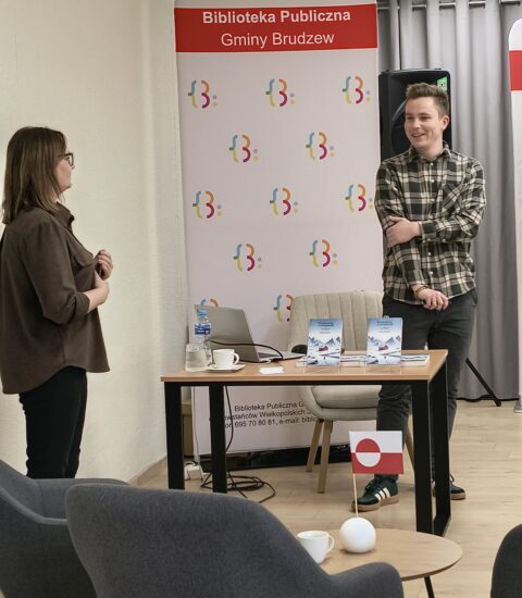 dyrektor biblioteki wita prowadzącego spotkanie podróznicze