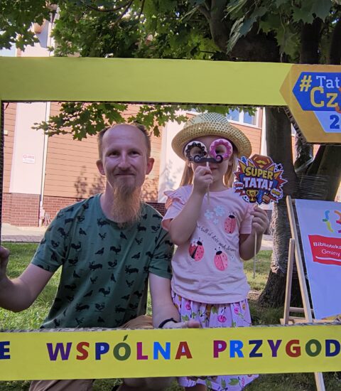 mężczyzna z małą dziewczynką w ramce promującej akcję czytania