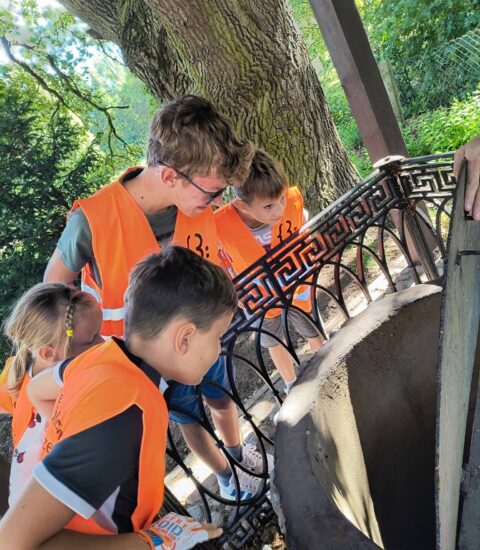 uczestnicy rajdu rowerowego przed kaplicą bł. Bogumiła w Dobrowie zaglądają do studni