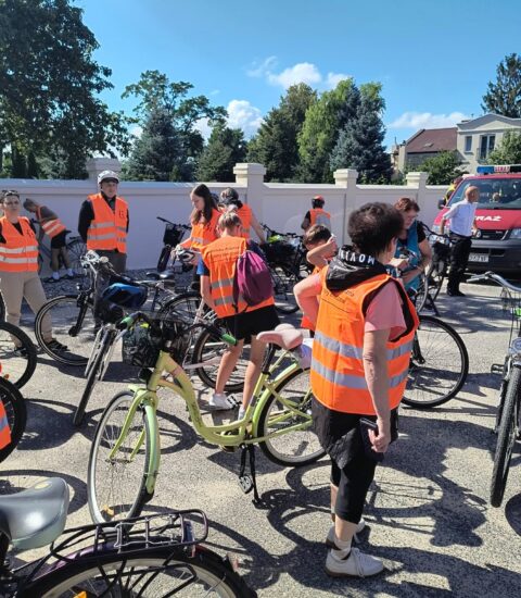 rowerzyści w pomarańczowych kamizelkach odblaskowych z rowerami