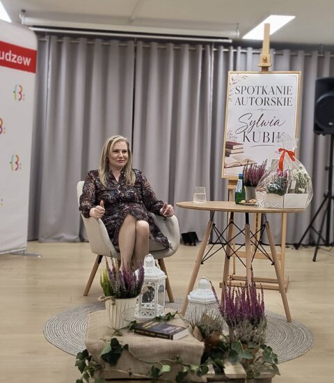 kobieta siedzi w fotelu, przed nią jesienna dekoracja z lampionami