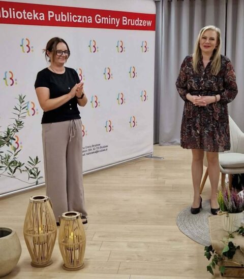 dyrektor biblioteki i autorka stoją na tle kolorowej ścianki