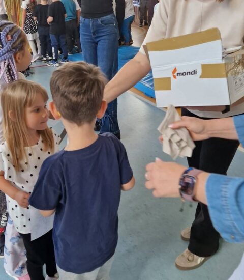 dyrektor biblioteki rozdaje dzieciom upominki